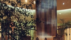 A wooden staircase with a wrought iron railing leading to a stone wall. - Denisa Boutique (Brasov)