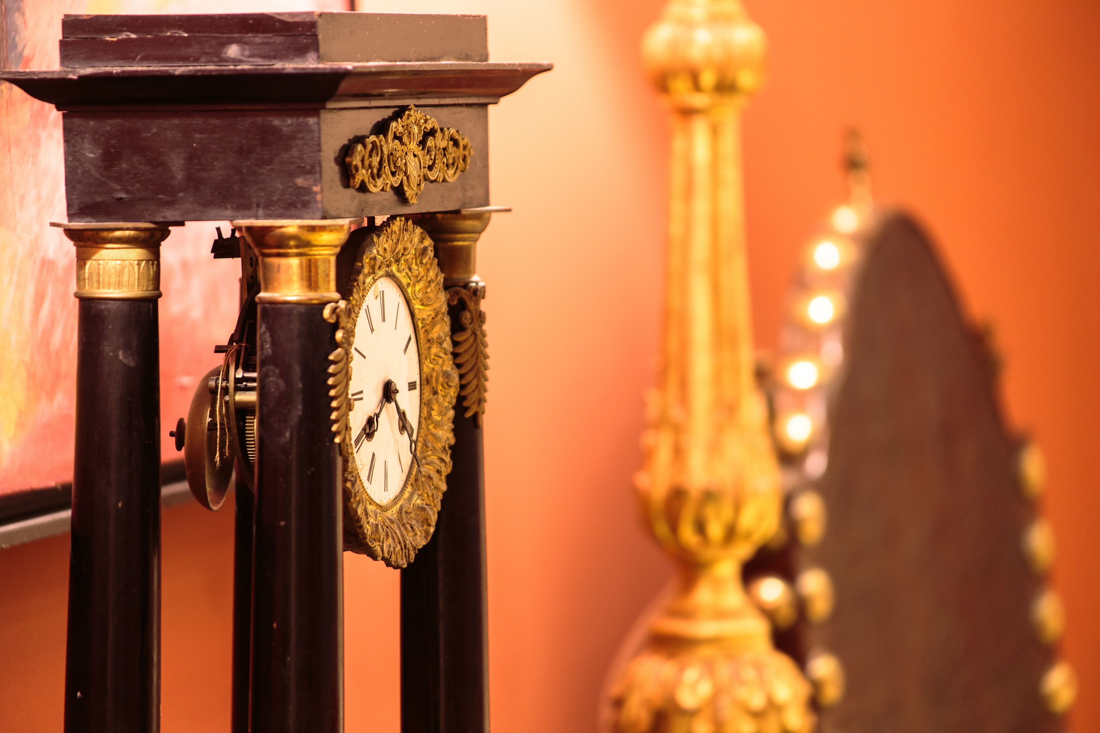Primer plano de un reloj con detalles dorados ornamentales y un diseño tradicional.