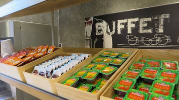 A buffet area with various food items including Andros yogurt and packaged snacks.