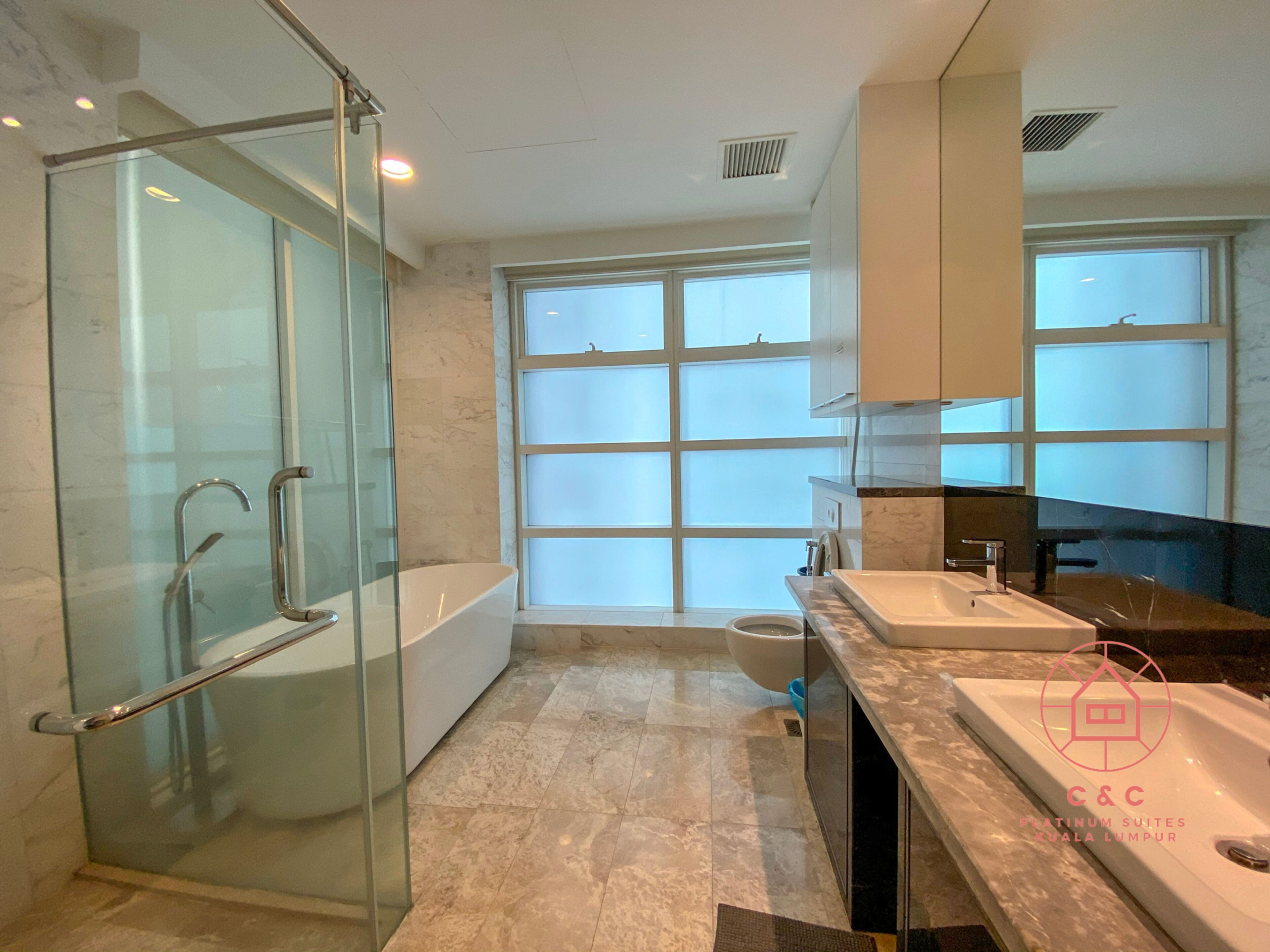 A modern bathroom with a glass-enclosed shower, a large window, and a vanity with a sink.