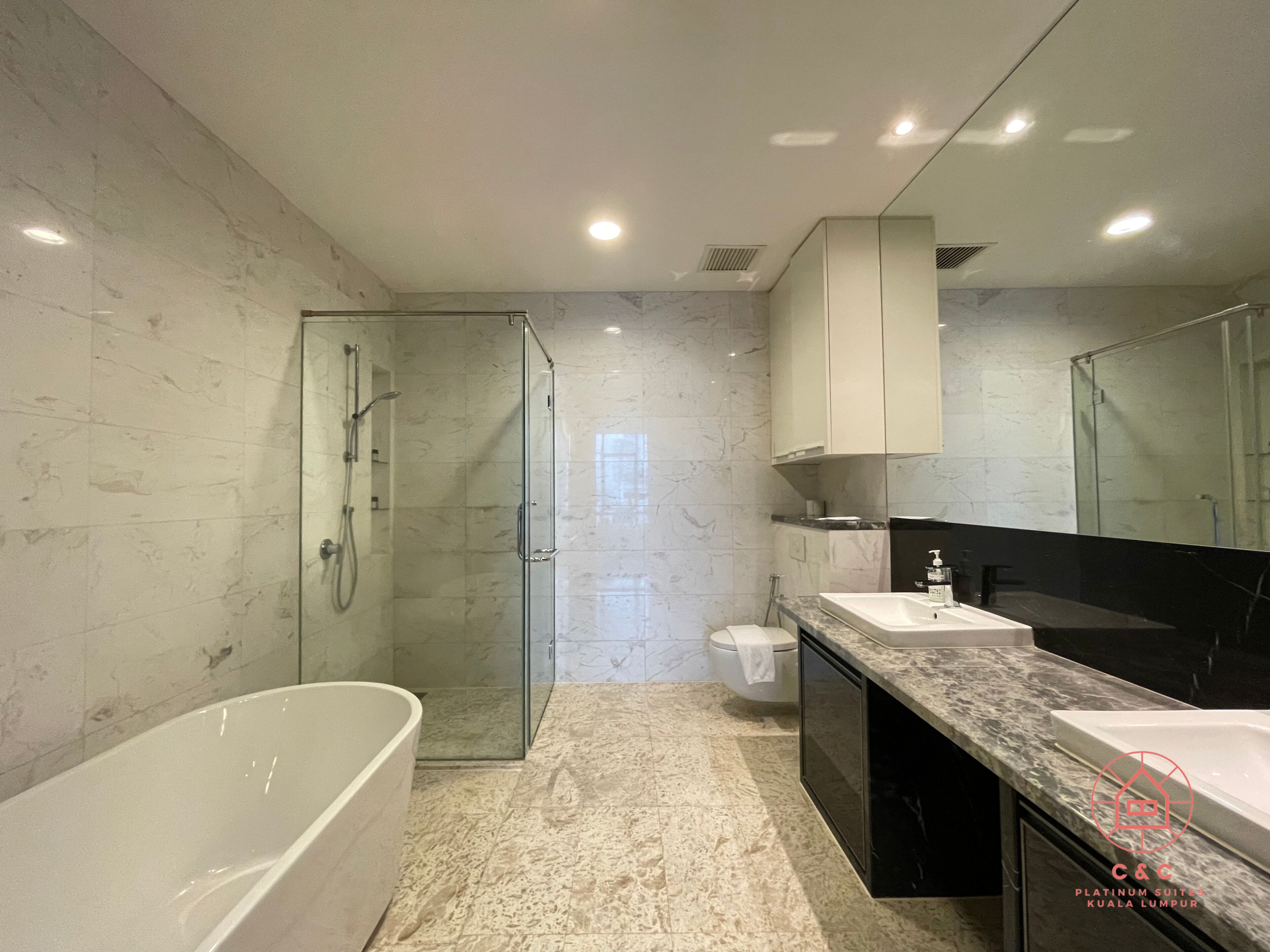 A modern bathroom with a glass-enclosed shower, a freestanding bathtub, and a large mirror above the sink.