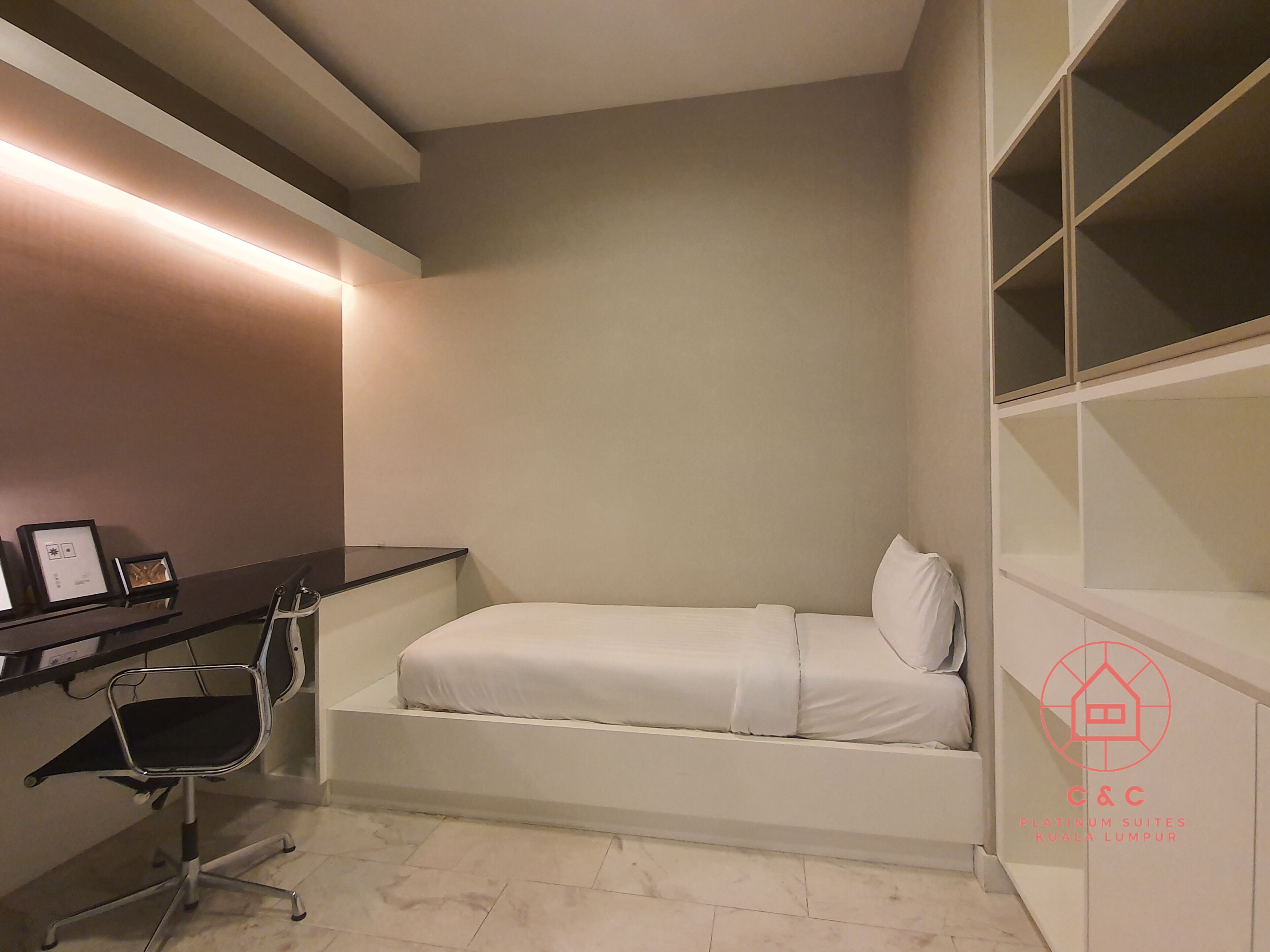 A compact bedroom with a bed, a desk, and a chair.