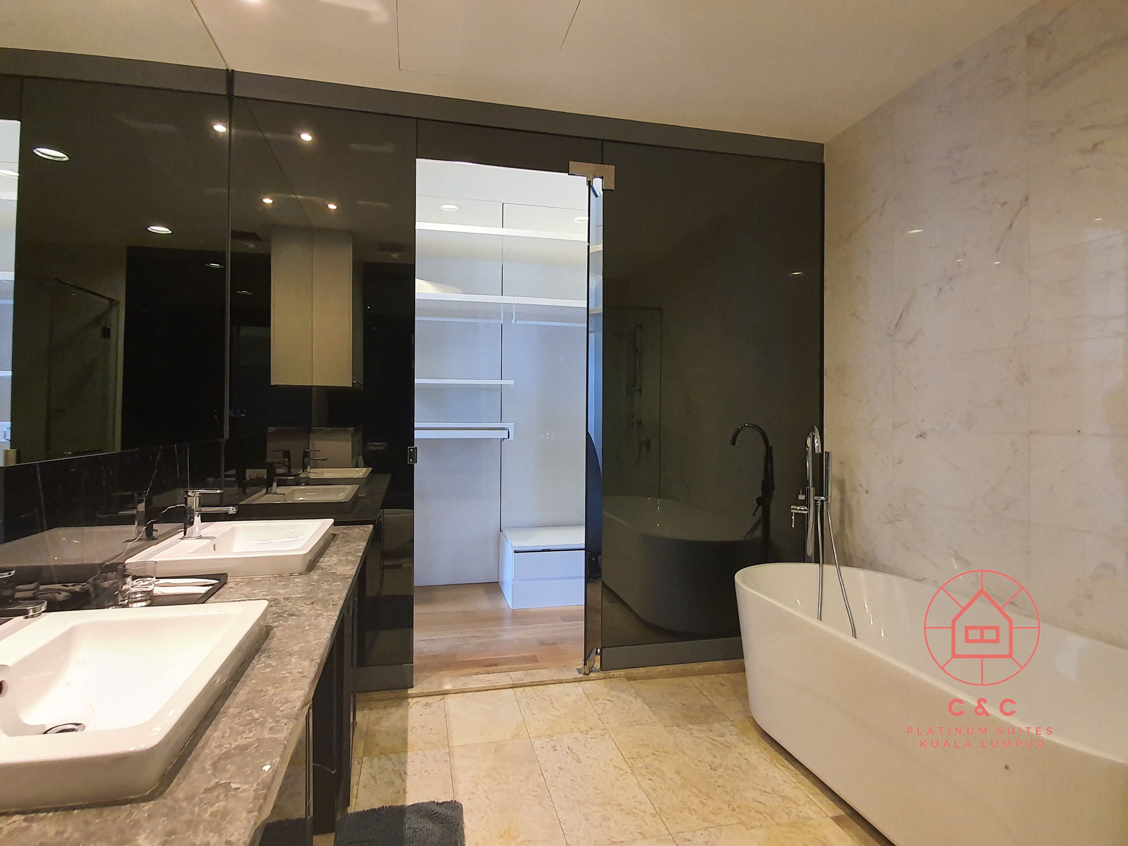 Une salle de bain moderne avec un grand miroir, deux lavabos, une baignoire et une douche à l’italienne.