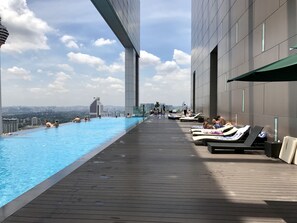 A rooftop infinity pool with lounge chairs and a city view. - The Platinum Suites (Kuala Lumpur)