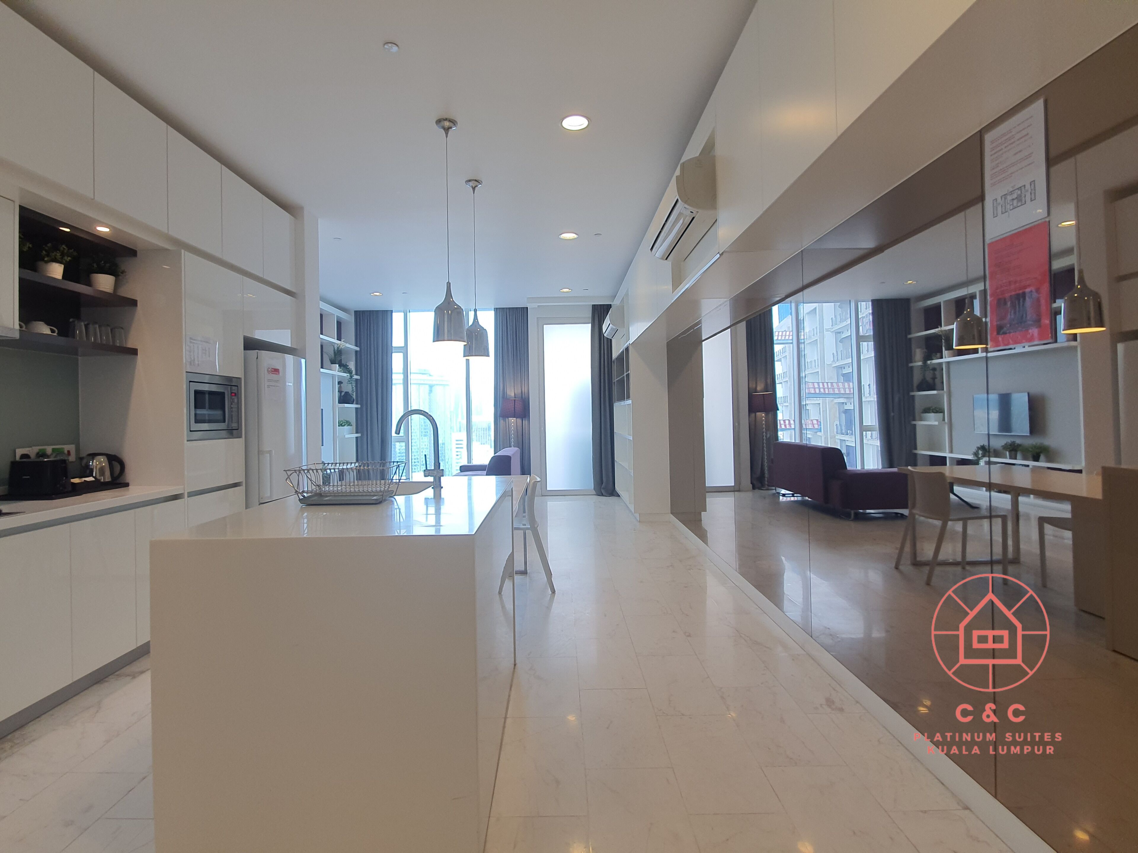 A modern kitchen with a central island, built-in microwave, and pendant lighting.
