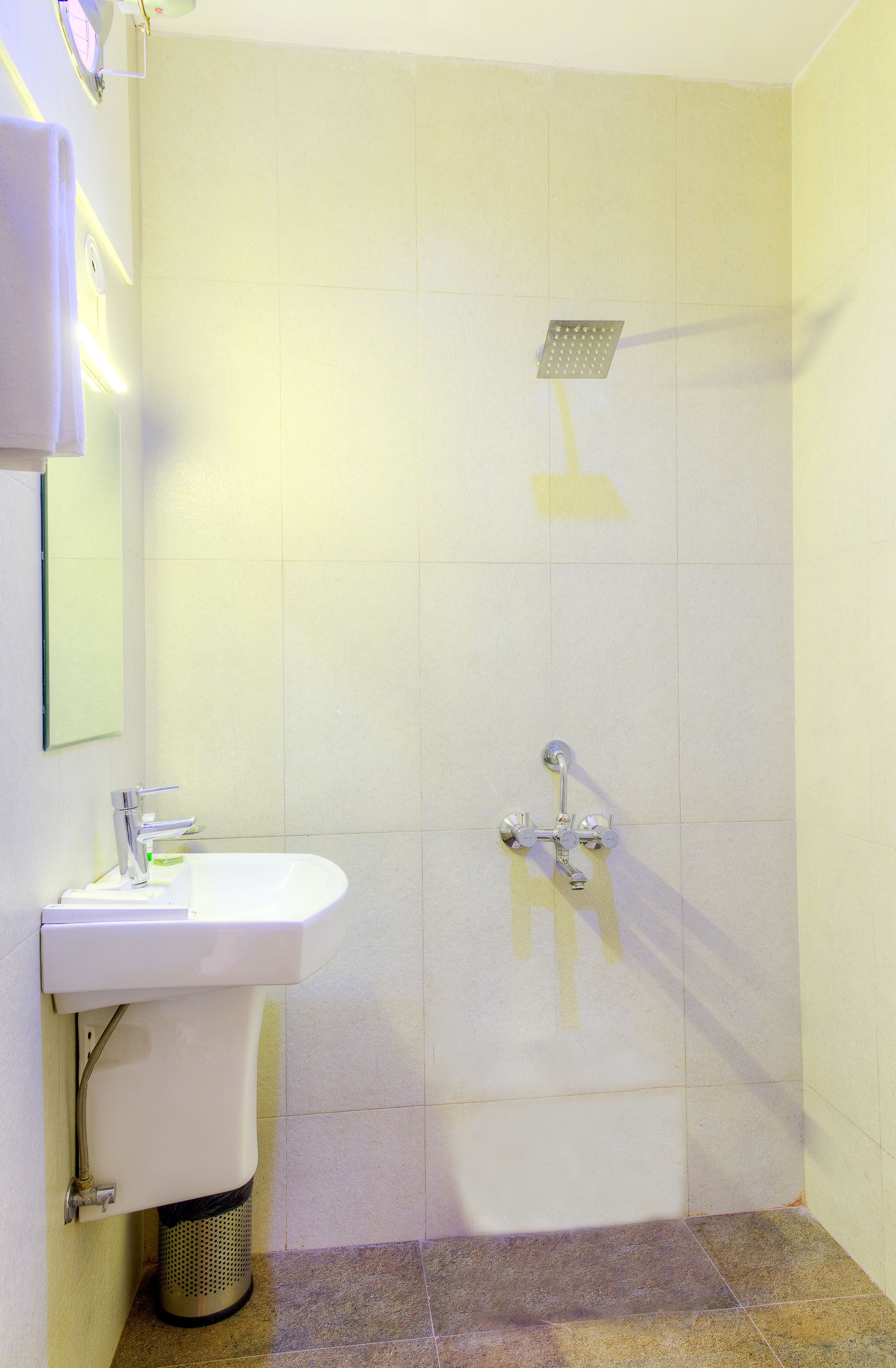 Een badkamer met wastafel, spiegel en douche.
