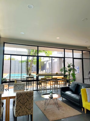 Un interior moderno con vista a la piscina, un comedor y un sofá.