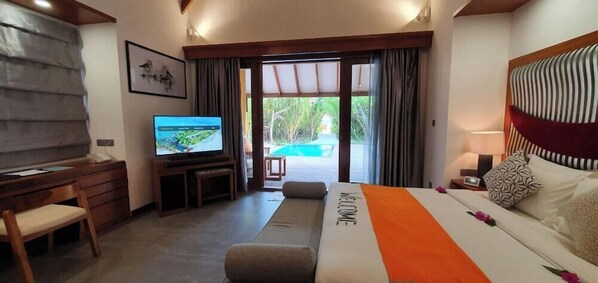 Une chambre d’hôtel avec un grand lit, une télévision, un bureau et une vue sur la piscine.