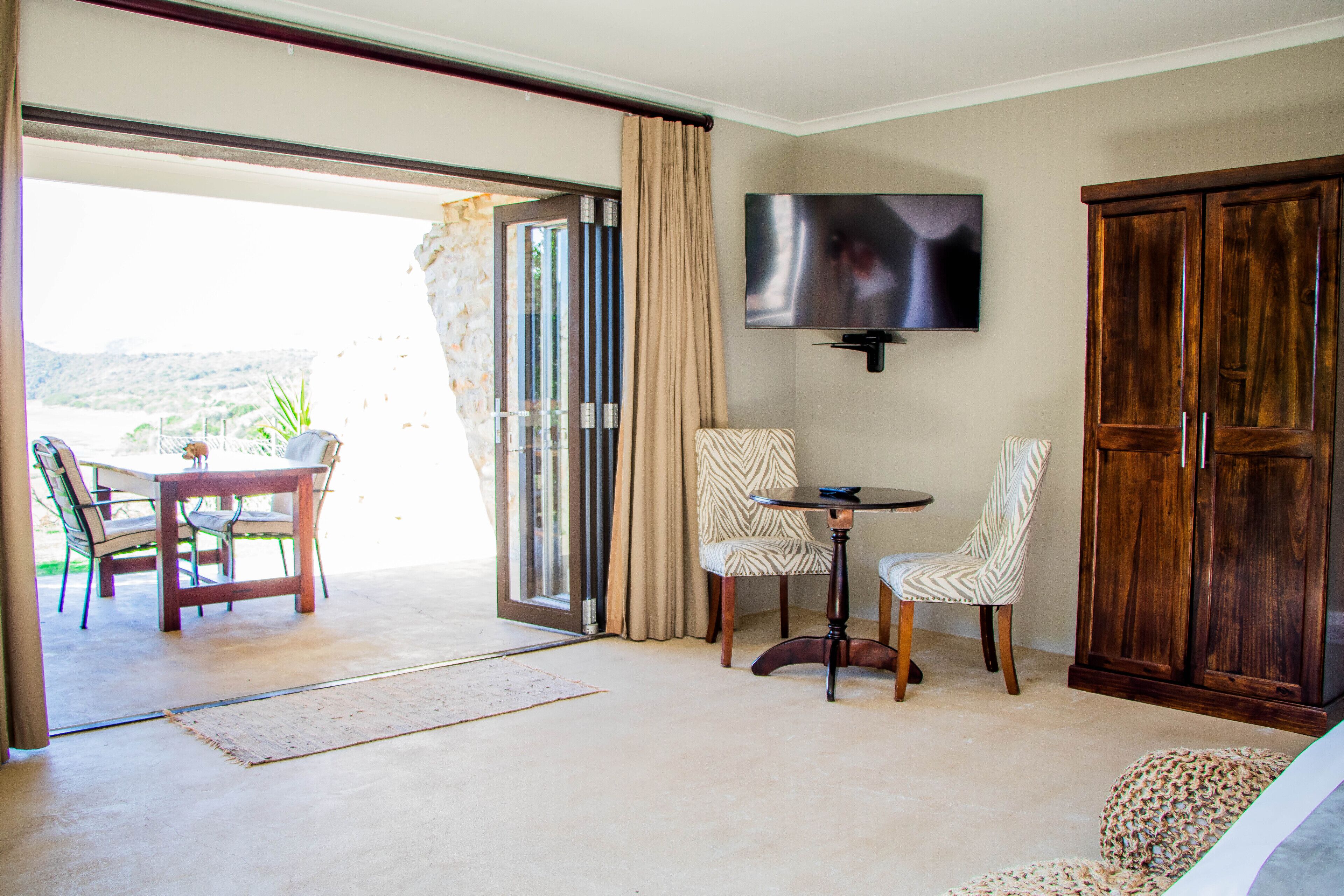 Quarto com porta de vidro deslizante que dá para um pátio, televisão montada na parede e um armário de madeira.