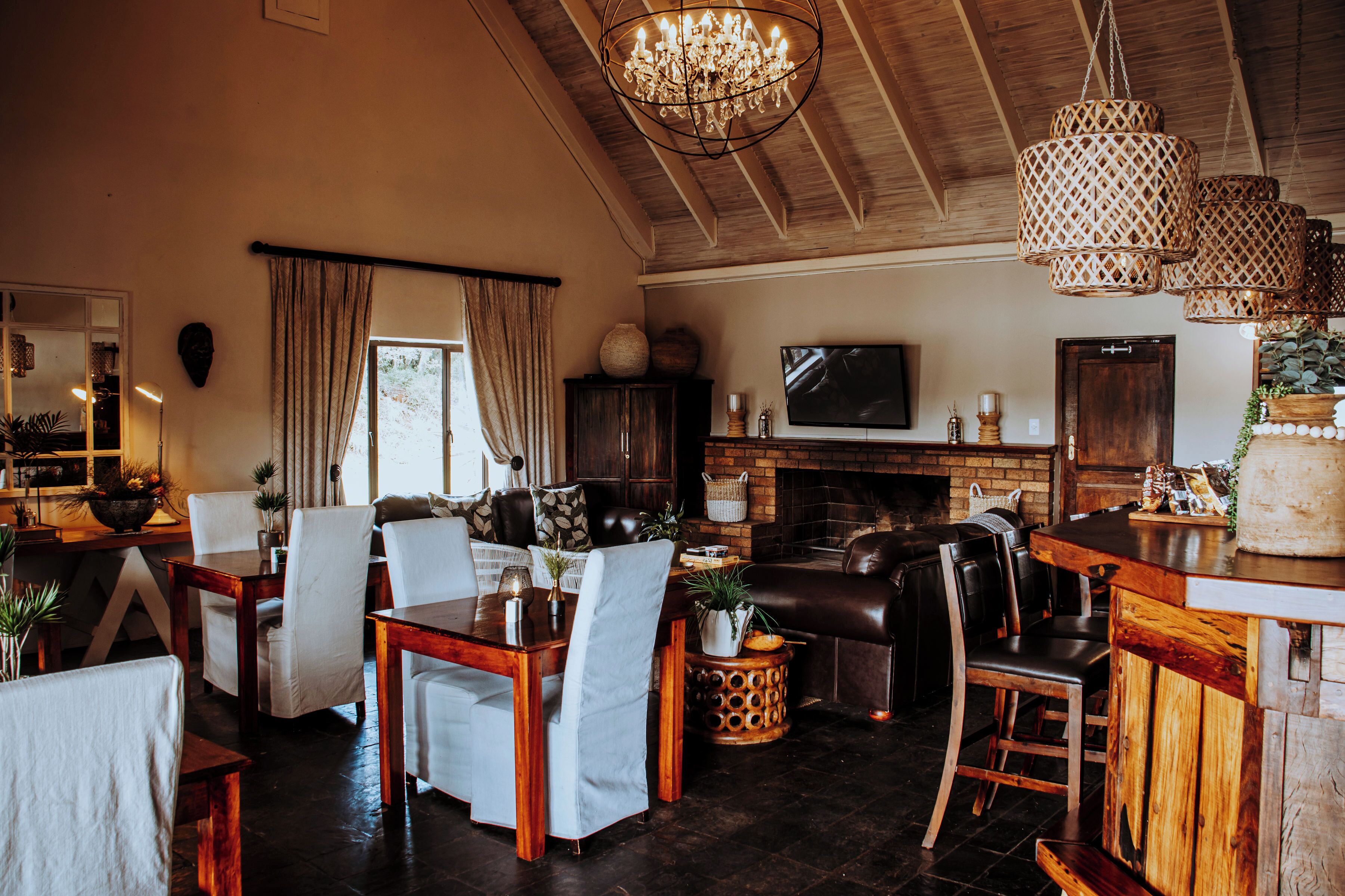 Un salón comedor amplio con chimenea, asientos de cuero y una barra.