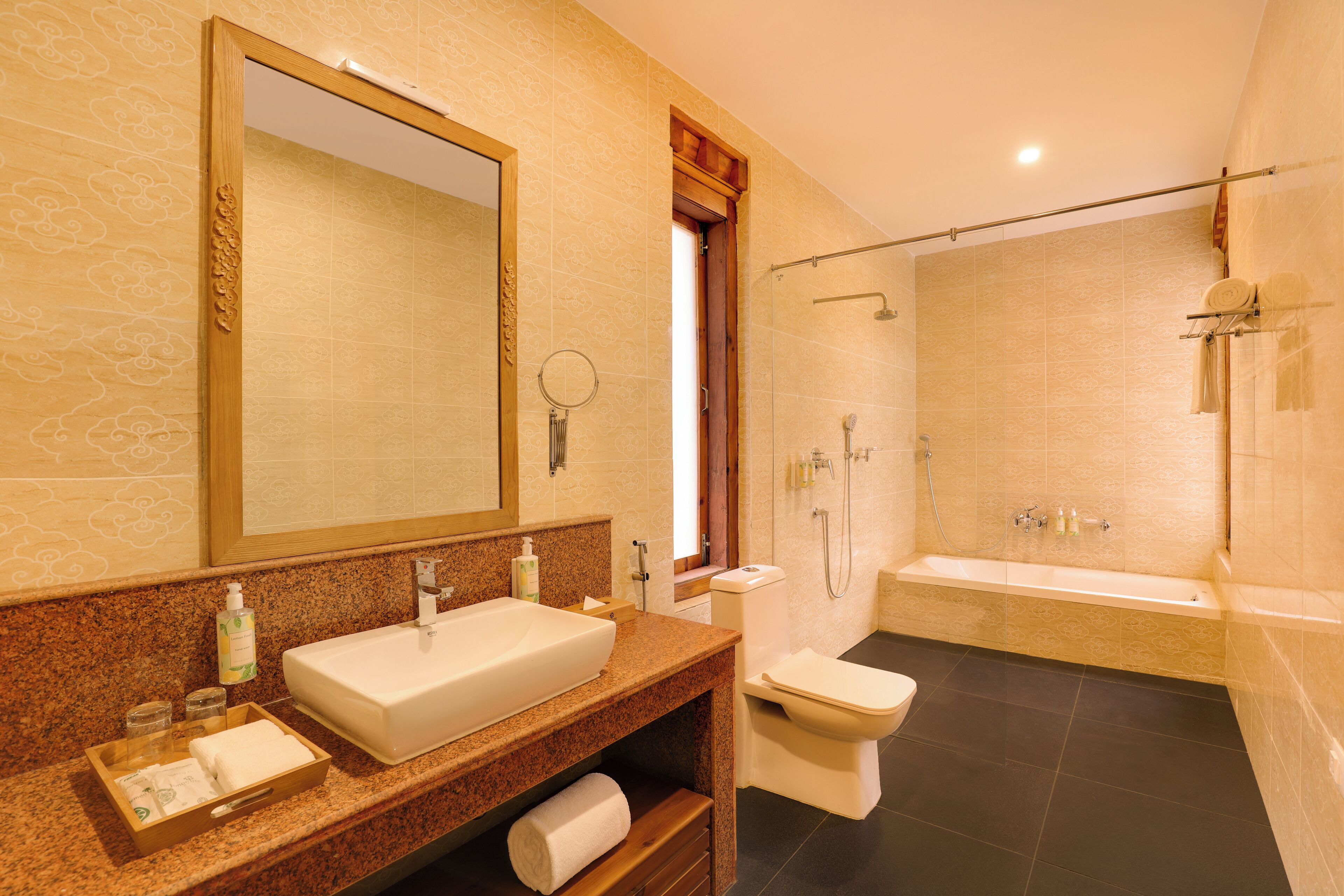A bathroom with a large mirror, a sink, a toilet, and a bathtub.