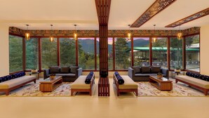 A spacious room with large windows, a central wooden column, and two sofas facing each other.