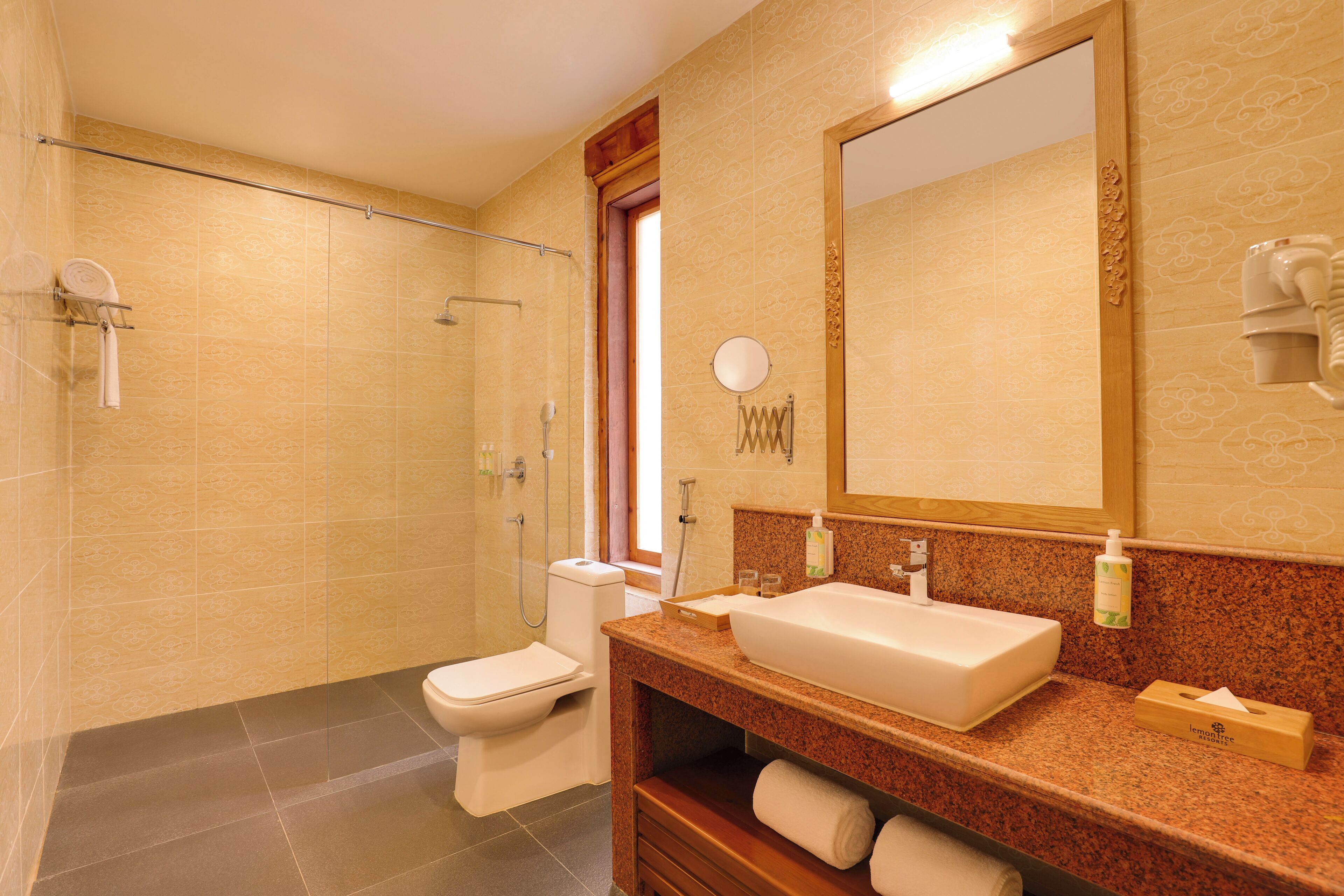A bathroom with a shower, toilet, sink, and mirror.