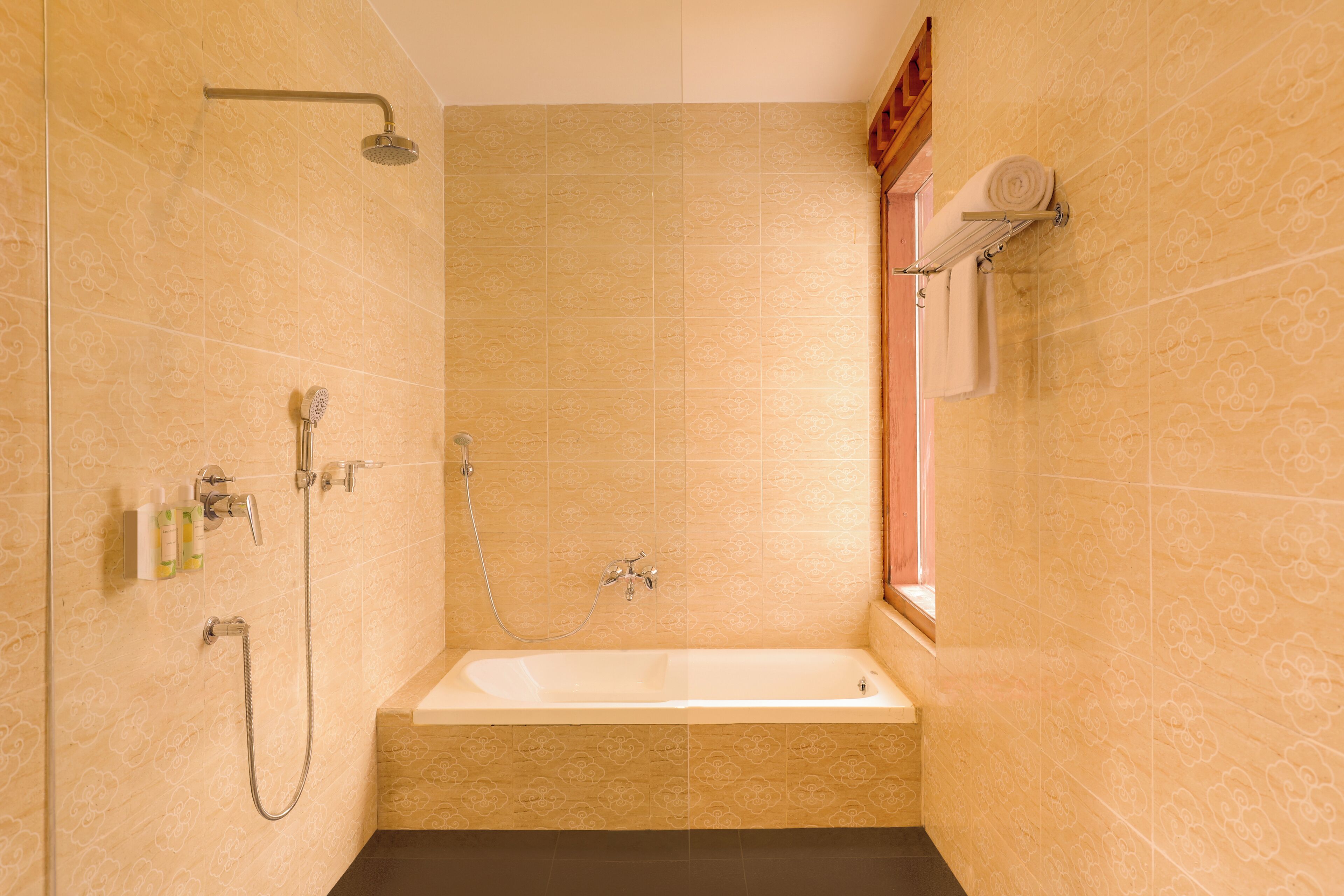 Un baño con bañera, ducha y un perchero para toallas.