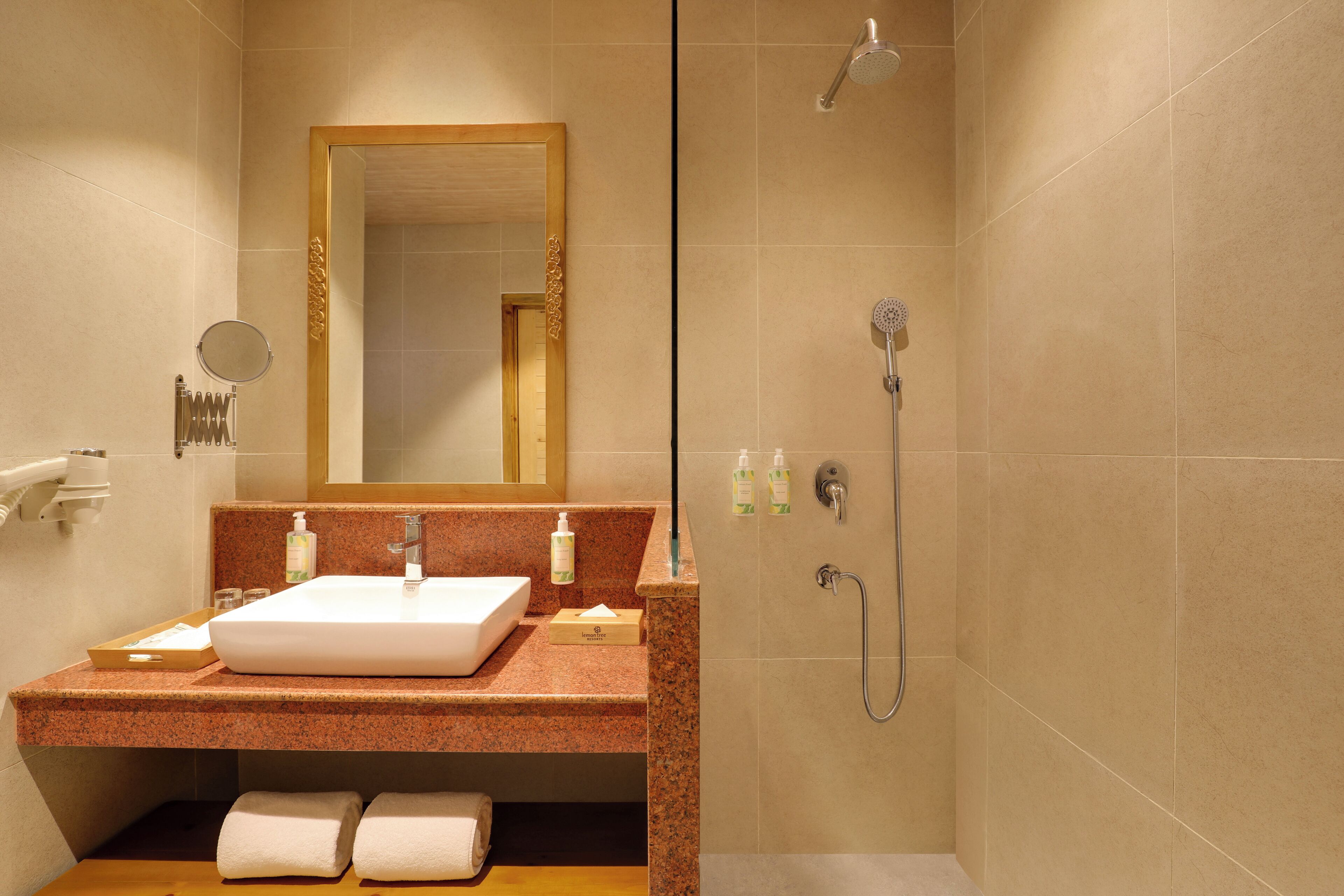 Une salle de bain équipée d’un lavabo, d’un miroir, d’un porte-serviettes et d’une douche.