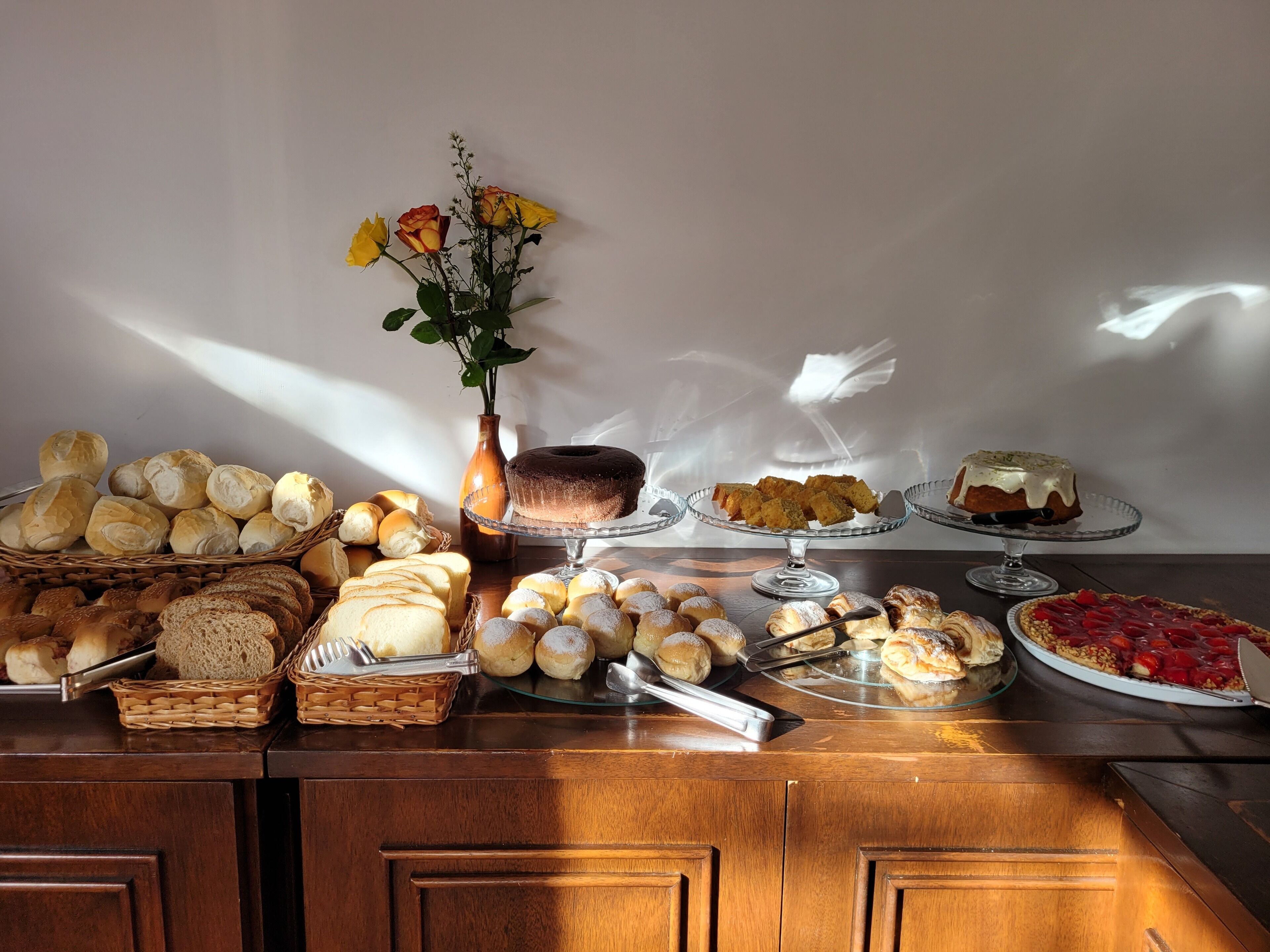 A buffet table with various baked goods, including bread, pastries, and a cake.