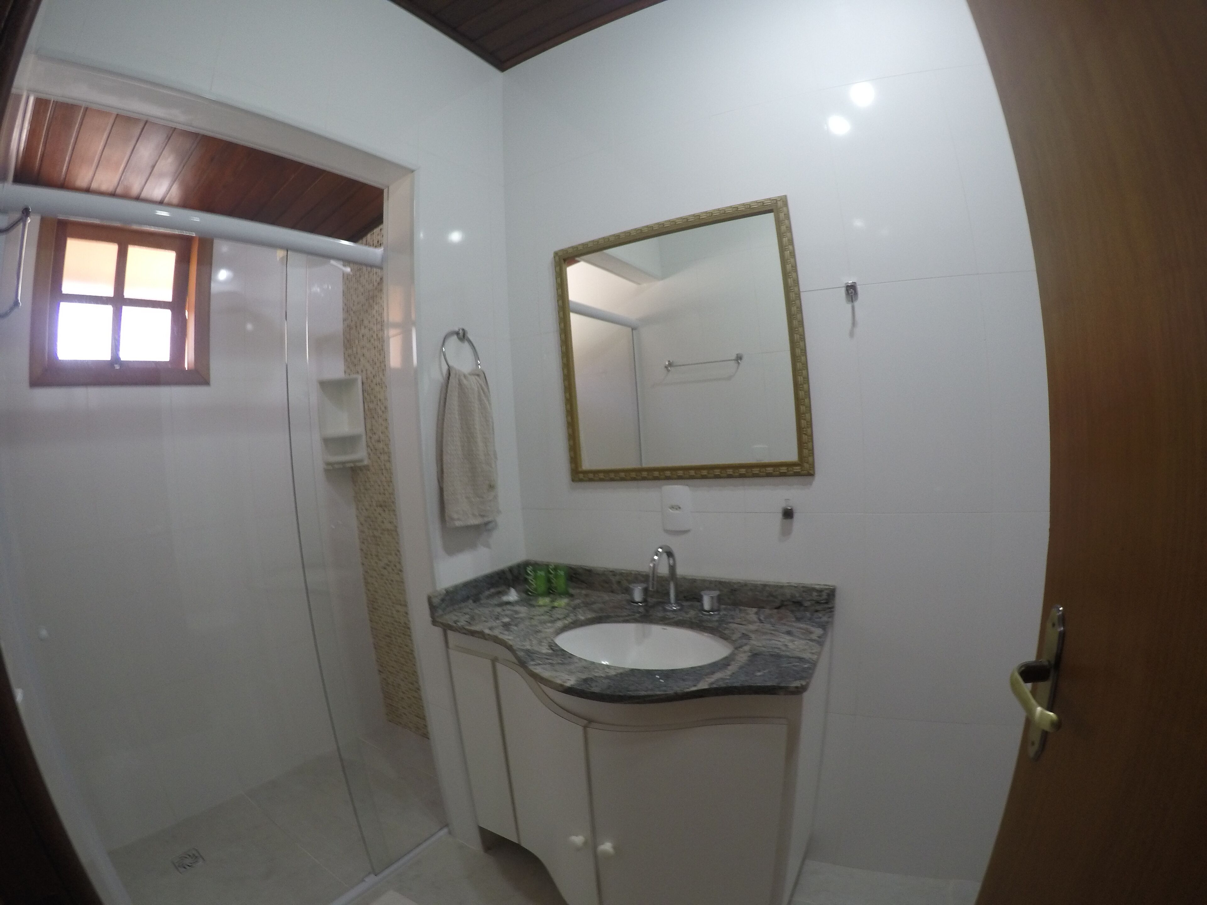 A bathroom with a shower, a sink, and a mirror.