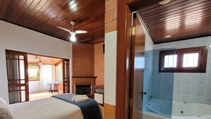 Un dormitorio con cama, chimenea y baño con bañera.