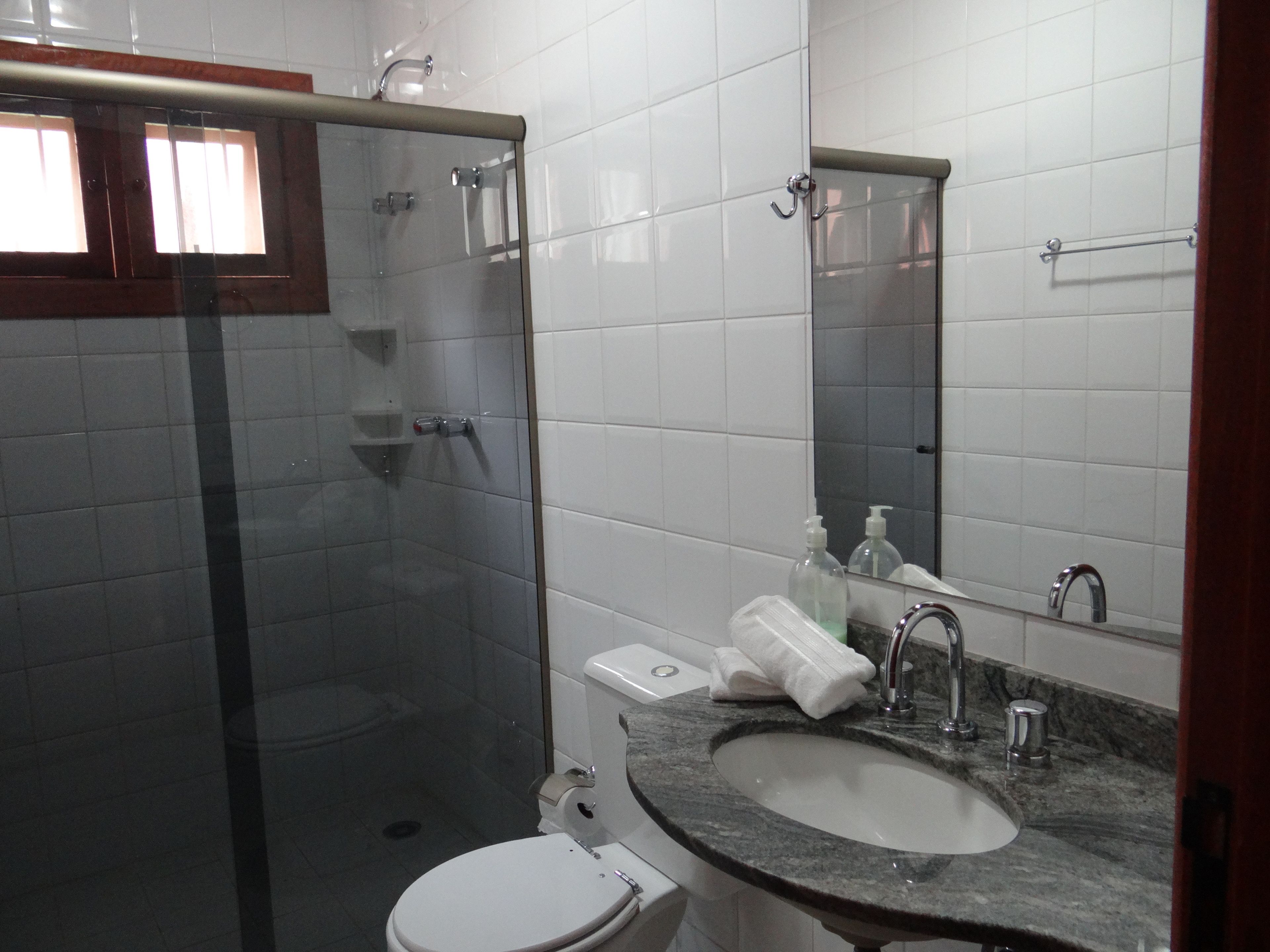 Ein Badezimmer mit Duschkabine, Waschbecken mit Marmorplatte und Toilette.