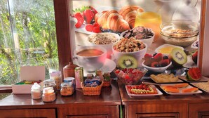 Un bufé de desayuno con frutas, bollería y bebidas variadas.