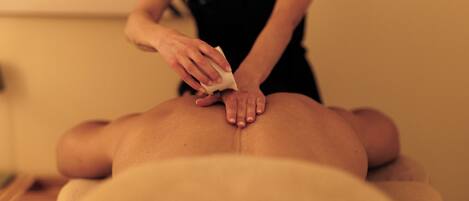 A person receiving a massage on a massage table.