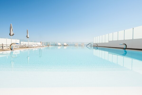 Seasonal outdoor pool, open 9:00 AM to 7:00 PM, pool umbrellas