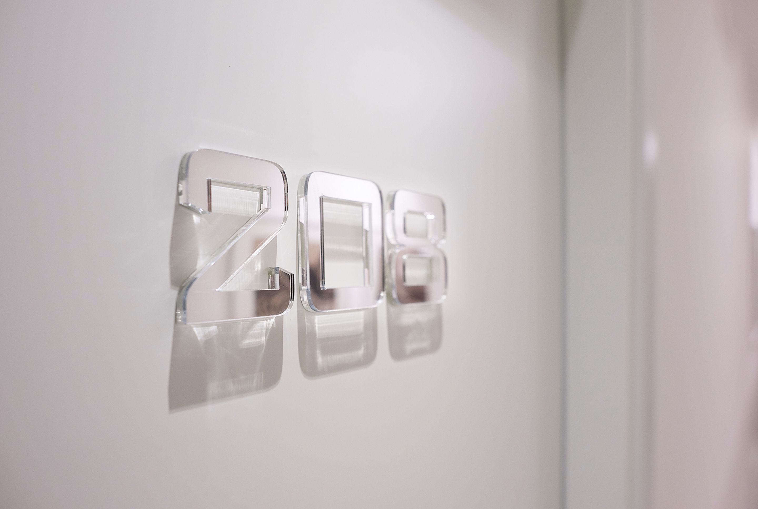 A wall with the numbers "2018" in a reflective, metallic finish.