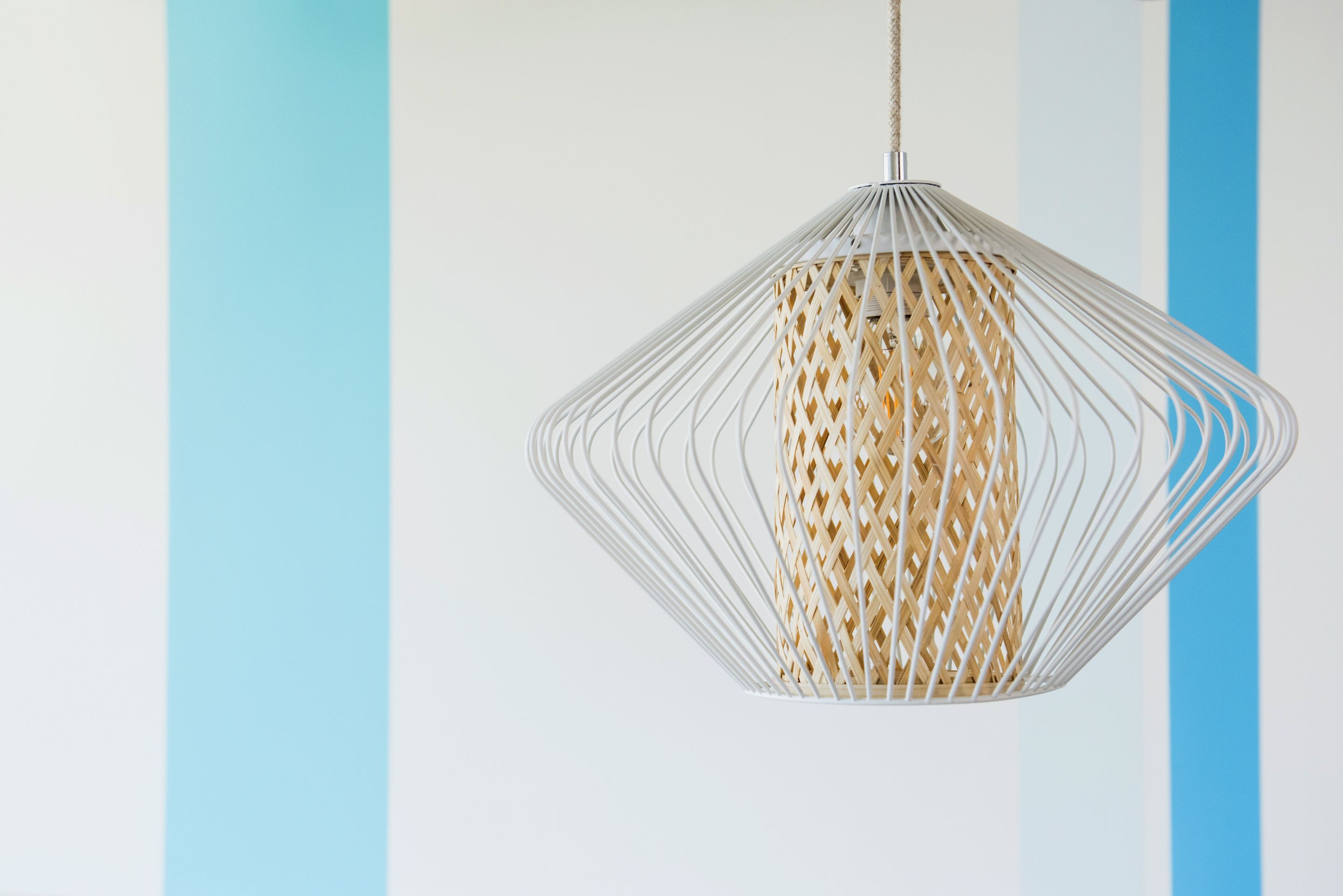 Een hanglamp met een gevlochten mandontwerp.