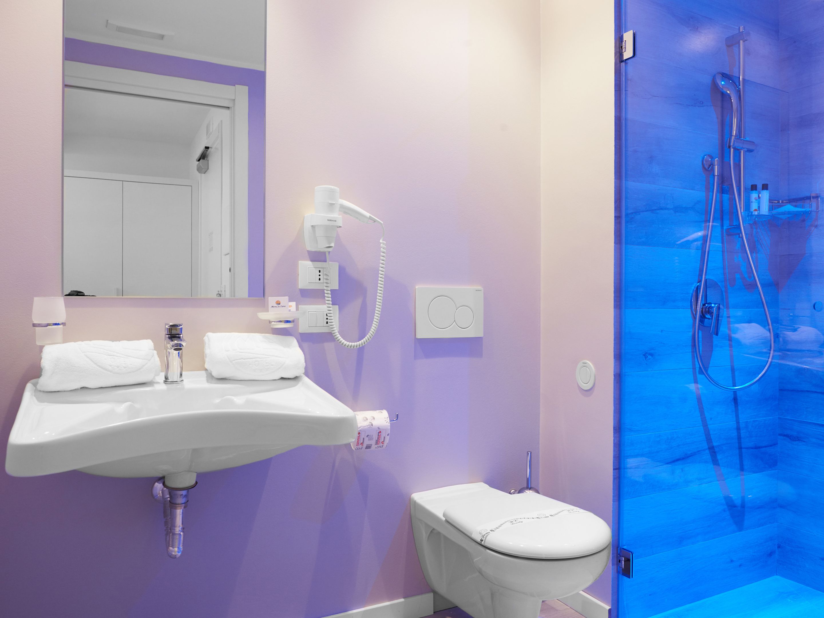 A bathroom with a white sink, a toilet, and a shower.