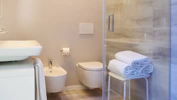 Un bagno moderno con doccia vetrata, lavandino bianco e water.
