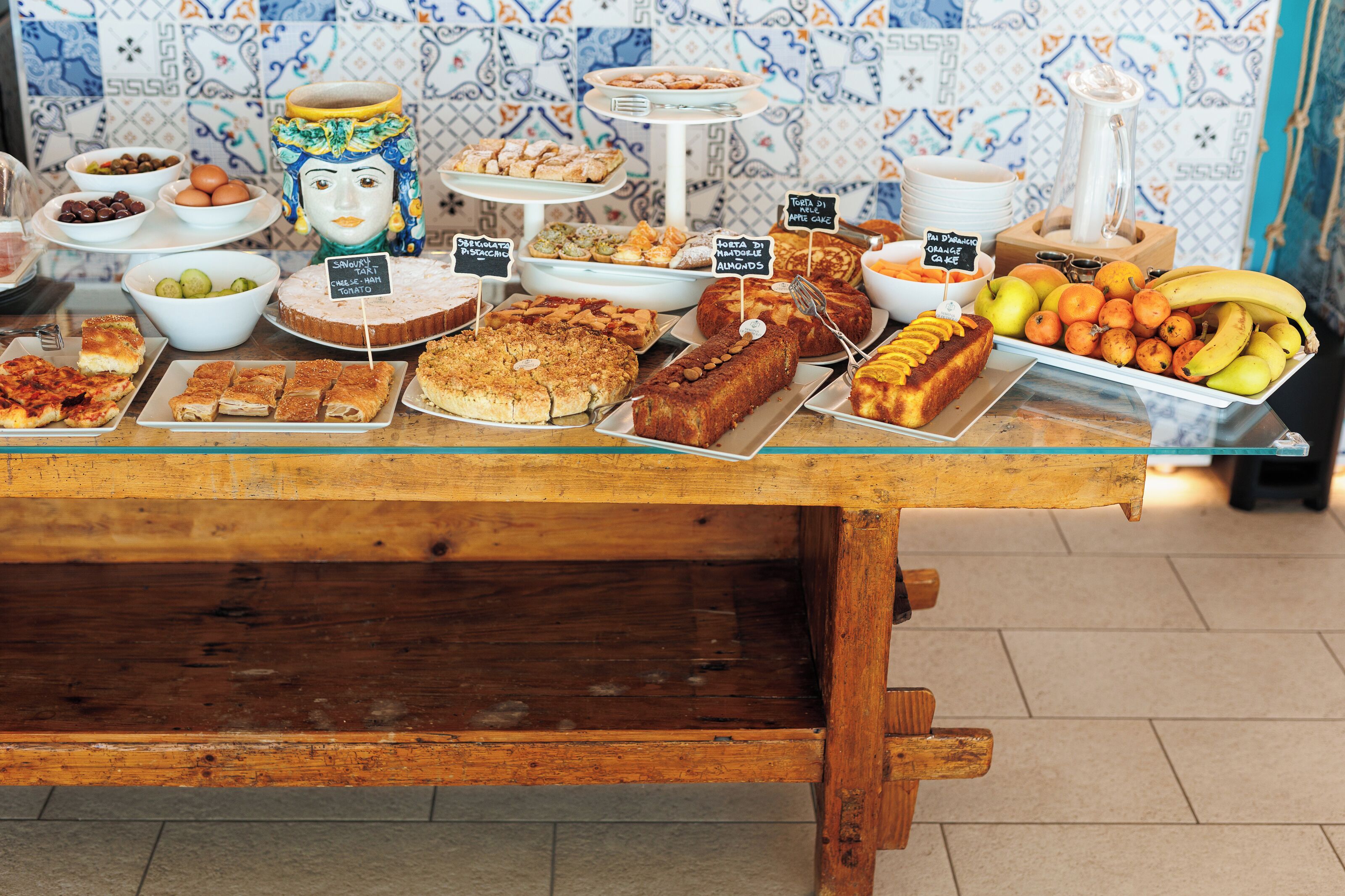 A buffet table with various food items and a decorative ceramic figure.