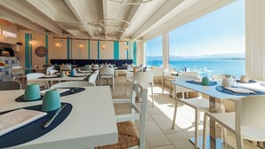 A restaurant with tables set for dining, a view of the sea, and a modern interior design. - Marina di Petrolo Hotel & SPA (Castellammare del Golfo)