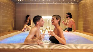 A hot tub with people sitting and holding champagne glasses. - Marina di Petrolo Hotel & SPA (Castellammare del Golfo)