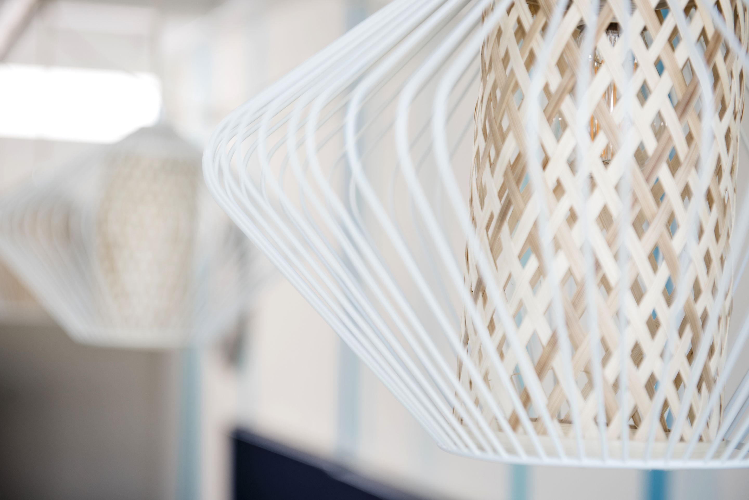 A close-up of a woven, conical light fixture with a lattice design.