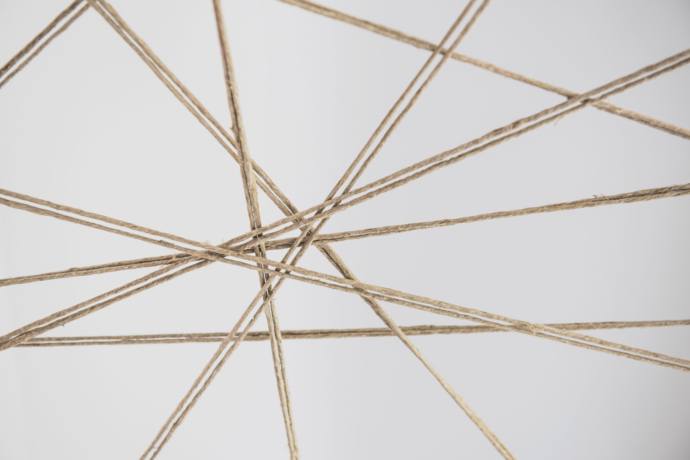 A close-up of a geometric structure made of intertwined ropes or strings.