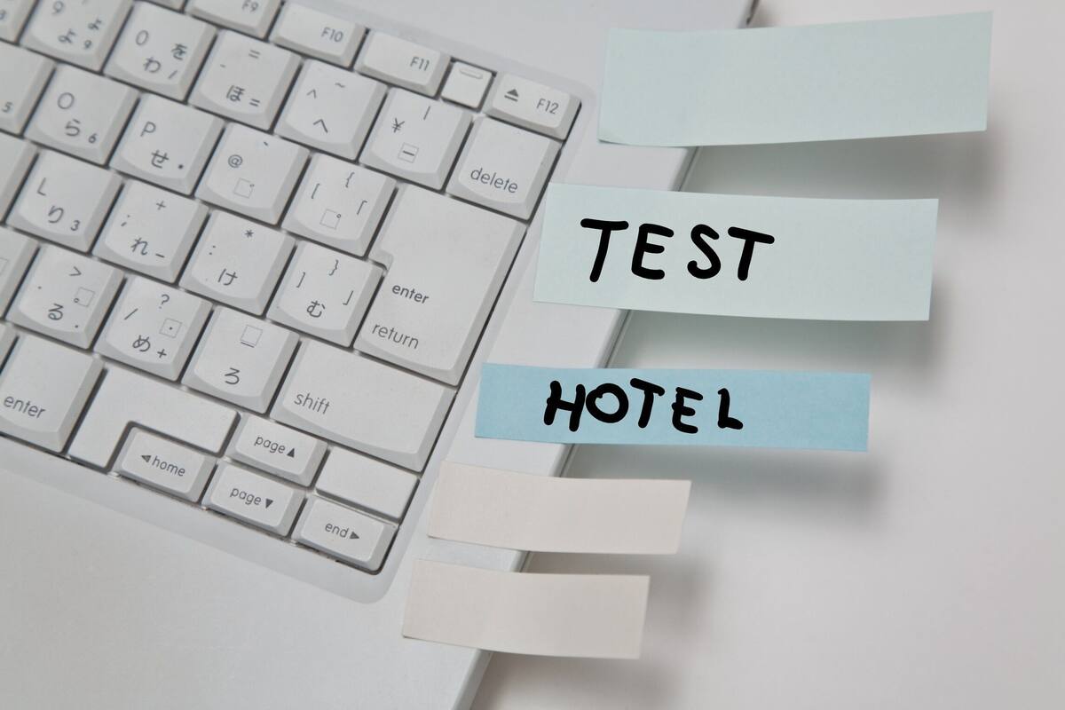 Un teclado con notas adhesivas que dicen 'TEST HOTEL'.