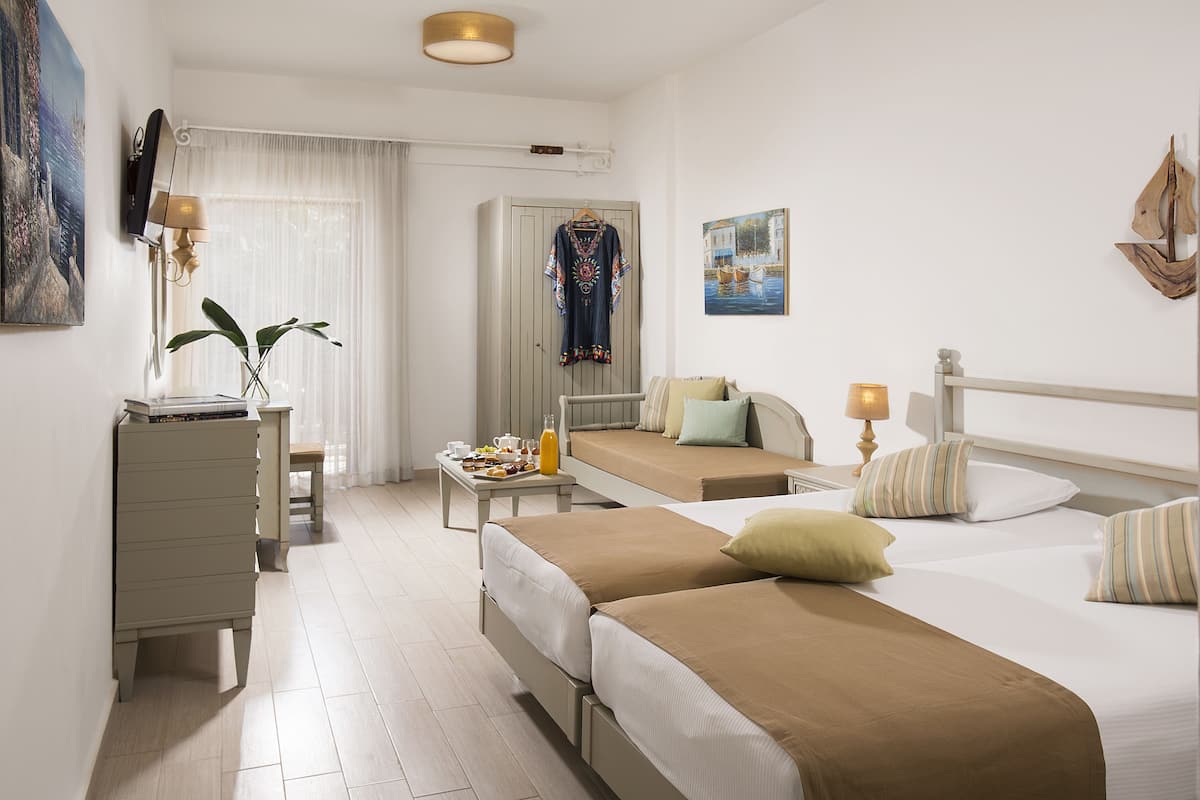 Habitación de hotel con dos camas, un escritorio, una cómoda, una ventana con cortinas y un cuadro en la pared.