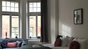 A room with a bed, a sofa, and a window. - Morris Hotel (Örebro)