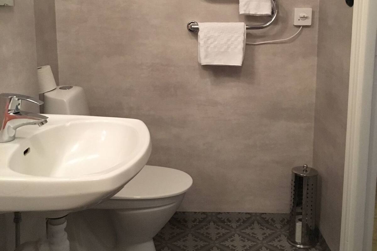 Kylpyhuone, jossa on wc, pesuallas ja kolme pyyhetelinettä.