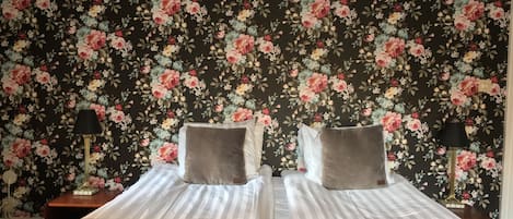 A double bed with striped bedding, two pillows, and folded towels.