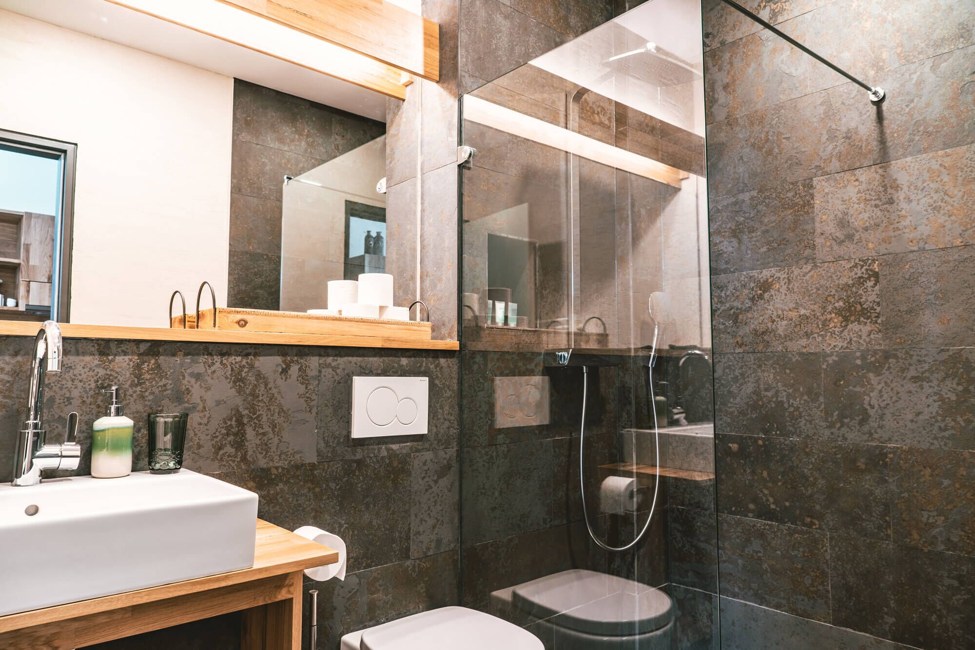 Une salle de bain moderne avec un lavabo, un miroir et une douche.