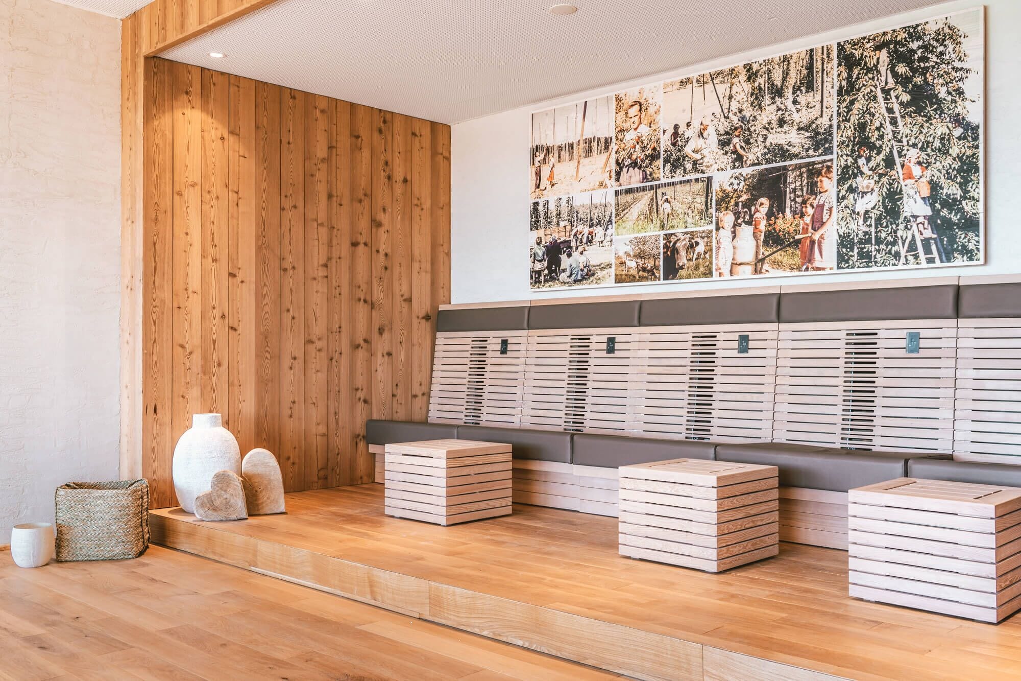 Una pared de madera con un gran collage de fotografías y una serie de cajas de madera.