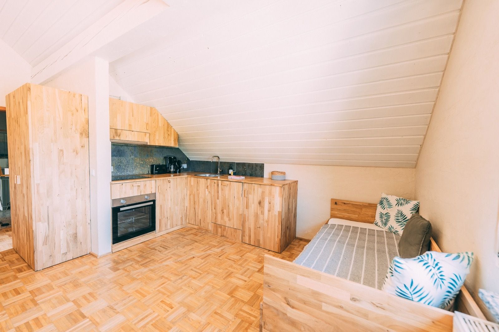A compact kitchen with wooden cabinets and a built-in oven.