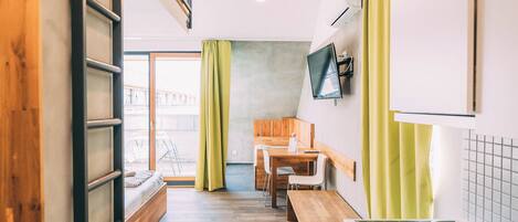 A modern kitchen with a wooden bench, a dining table, and a built-in stove.