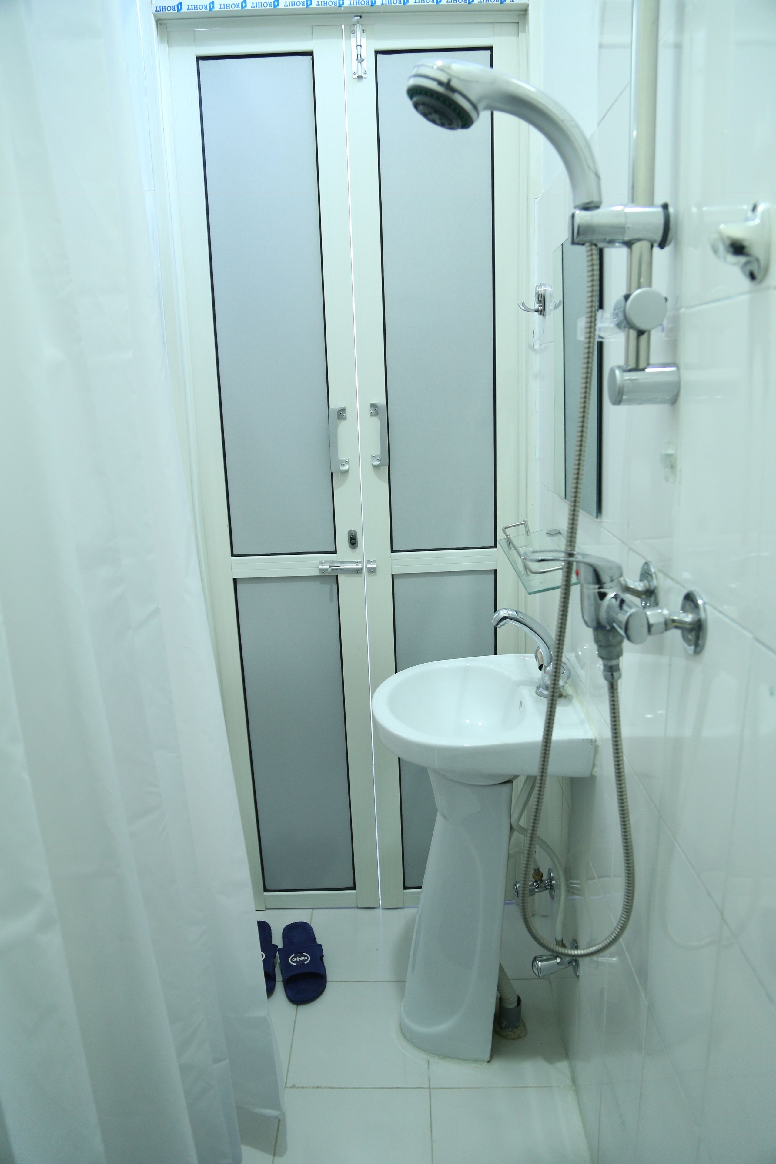 A bathroom with a shower, sink, and a glass door.