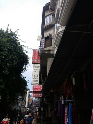 A narrow street with multiple signs and a building facade. - Bed and Breakfast Thamel (Kathmandu)