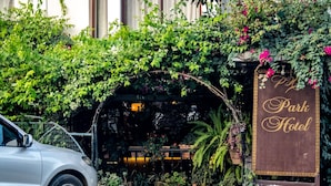 Un coche estacionado frente a un edificio con un letrero que dice 'Park Hotel'.