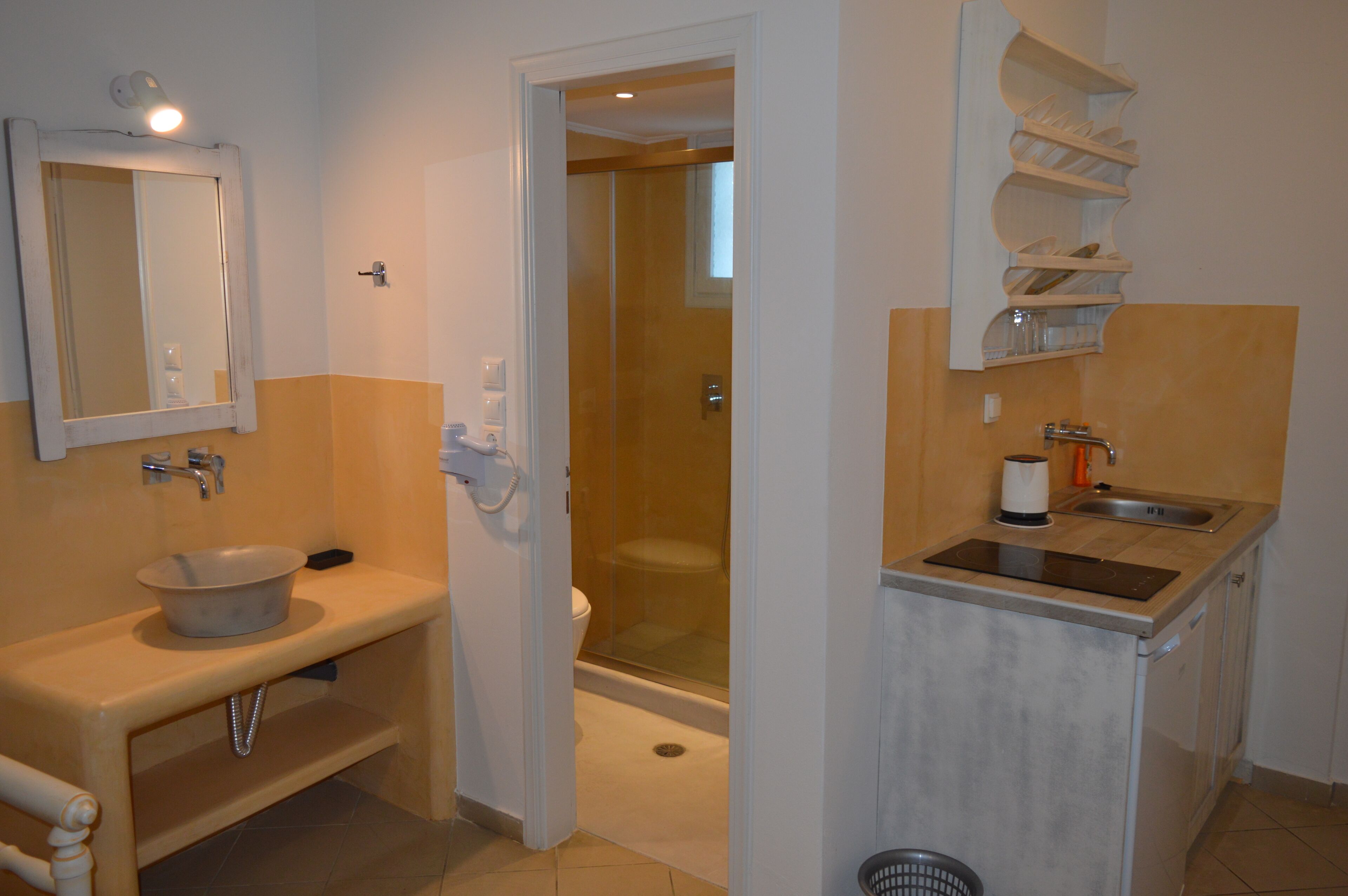Ein Badezimmer mit Waschbecken, Spiegel, Toilette und Duschbereich.