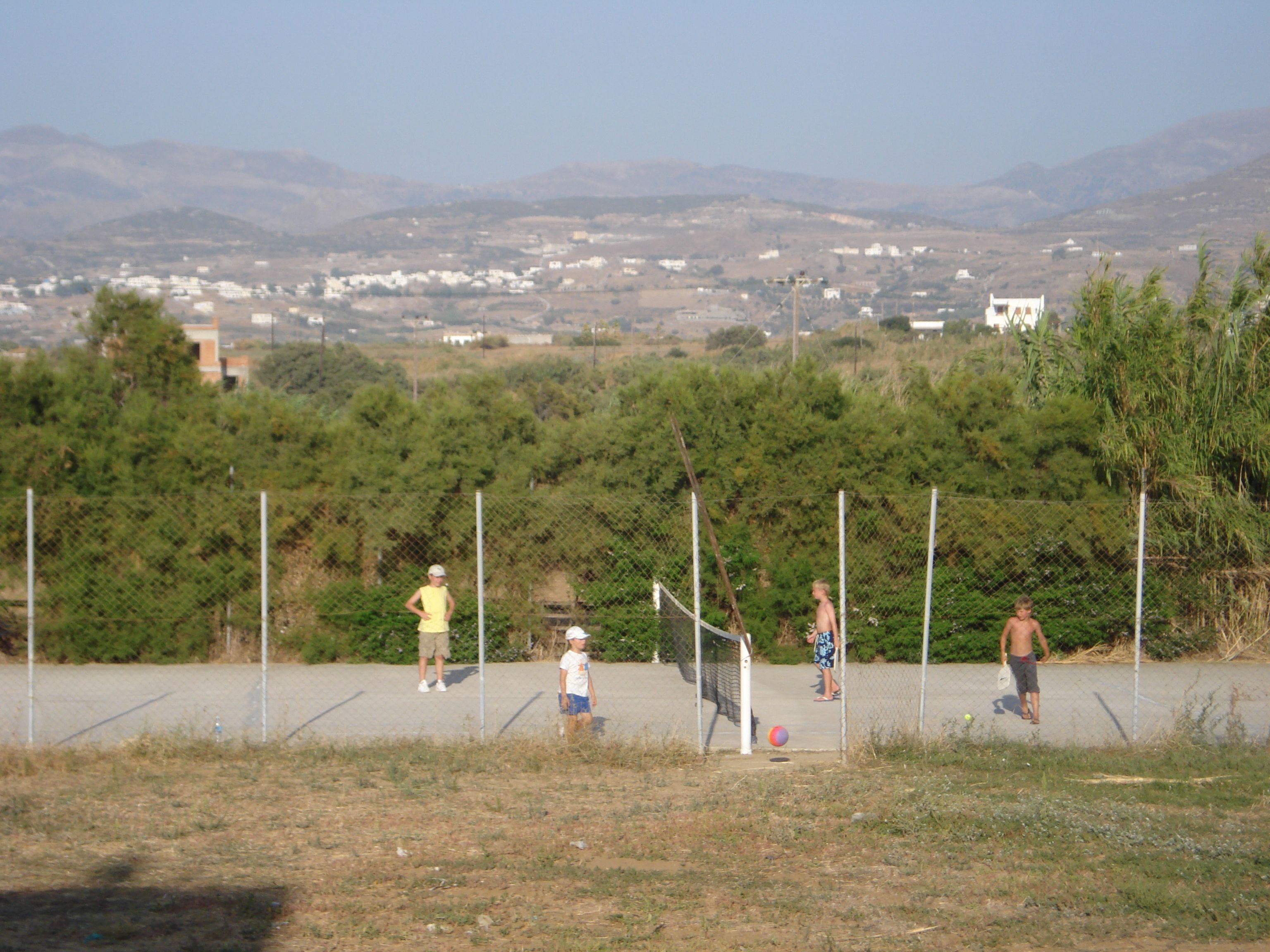A fenced outdoor area with a clear view of distant buildings and hills.