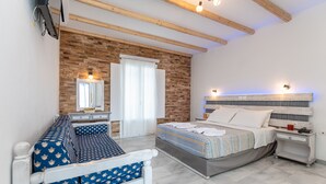 Un dormitorio con cama, sofá, mesita de noche y espejo.